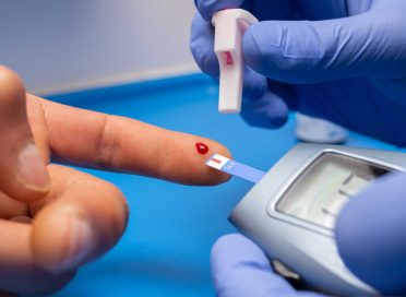 A closeup shot of a doctor with rubber gloves taking a blood test from a patient